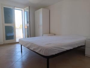 un grande letto in una stanza con una grande finestra di Residenza Maria Antonia - Appartamento Francesco a Orosei