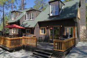 a house with a large wooden porch with a patio at Hobbit House - Charming In Town in Idyllwild