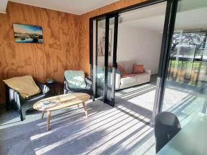 - un salon avec une table, des chaises et des portes coulissantes en verre dans l'établissement Hagley Park Views, à Christchurch