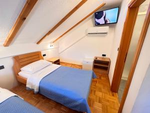 1 Schlafzimmer mit 2 Betten und einem Flachbild-TV in der Unterkunft Apartman Miramare in Otočac