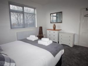 - une chambre avec un lit, une commode et un miroir dans l'établissement Bright Spacious Home with Parking - Haughton, à Darlington