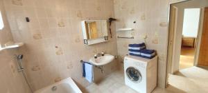 a bathroom with a washing machine and a sink at Apartment Popp Langen in Langen +8 photos