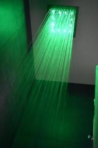 y baño con ducha con luces verdes. en Blue Star Inn, en Houston