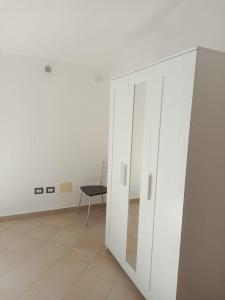 un armadio bianco e una sedia in una stanza di Residenza Maria Antonia - Appartamento Francesco a Orosei
