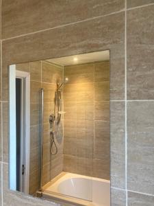 a shower in a bathroom with a mirror at Chessington Home Stay , 3 Bed 6 Guests Free Parking Near M25 JCT9, Chessington world of Adv Resort, Kingston, Epsom, Great for Families & Groups in Chessington