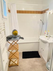uma casa de banho com uma banheira branca e um lavatório. em Studio Piscine Honfleur Deauville em Équemauville