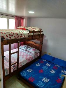 a bedroom with two bunk beds and a window at Lujoso apartamento amoblado a tan solo dos cuadras del parque principal. in Santa Rosa de Cabal