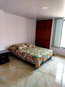 a bedroom with a bed with a colorful bedspread at Lujoso apartamento amoblado a tan solo dos cuadras del parque principal. in Santa Rosa de Cabal