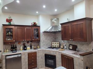 a kitchen with wooden cabinets and a stove at Appartamento in villa Ryder Cup in Marco Simone