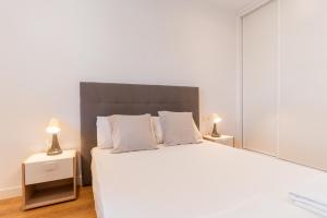 ein Schlafzimmer mit einem großen weißen Bett mit zwei Lampen in der Unterkunft Trendy Homes Vega de Acá in Almería