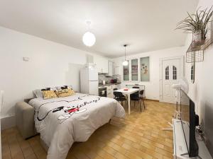 a bedroom with a large bed and a kitchen at La Maison de Mickey - Disneyland et Paris in Bailly-Romainvilliers