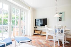 sala de estar con mesa, sillas y TV en Haus-Moin en Munkmarsch