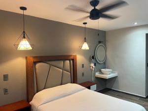 - une chambre avec un lit et un ventilateur de plafond dans l'établissement Hotel Casa María Tamasopo, à Tamasopo