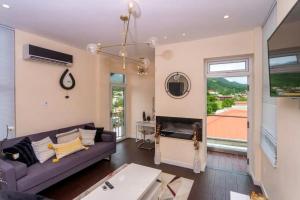 - un salon avec un canapé violet et une cheminée dans l'établissement Holiday Apartment Dominica, à Glanvillia