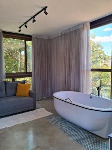 ein großes Bad mit einer Badewanne und einer Couch in der Unterkunft Ecolounge Studios in Pirenópolis