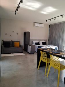 een woonkamer met een bank en een tafel en stoelen bij Ecolounge Studios in Pirenópolis
