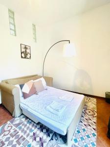 Avdkapartment في ميلانو: غرفة نوم صغيرة مع سرير وأريكة