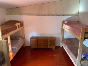 a room with two bunk beds and a wooden table at Alojamiento hostel Lodeolga "La Florida" in Rosario