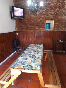 Cama en habitación con TV de pantalla plana en Alojamiento hostel Lodeolga "La Florida" en Rosario