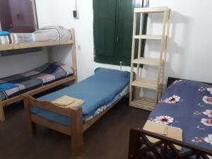 a room with two bunk beds and a table at Alojamiento hostel Lodeolga "La Florida" in Rosario