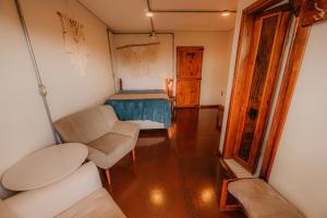 Habitación con cama, sofá y silla en Pousada Campeira, en Brotas