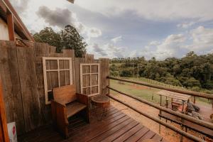 a wooden deck with a bench and a table on it at Pousada Campeira in Brotas