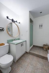 een badkamer met een toilet, een wastafel en een spiegel bij The Érablière, 3 bedrooms, 7 people in Saint-Férréol-les-Neiges