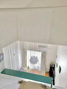 um quarto com uma cama e uma janela com cortinas em （201室) 成田机场附近宁静惬意的房子，8日以上免费接机 
