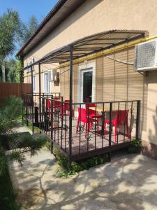un patio con tavoli e sedie rossi in un edificio di Бабай Садиба a Vasylʼkiv
