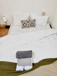 uma cama branca com uma pilha de toalhas em （201室) 成田机场附近宁静惬意的房子，8日以上免费接机 