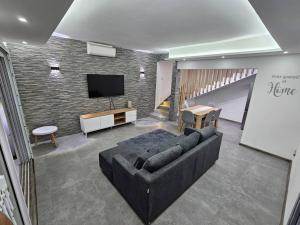 a living room with a couch and a flat screen tv at Rooftop Spa Luxury Villa in Rivière Noire