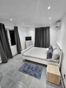 Dormitorio blanco con cama y mesa en Rooftop Spa Luxury Villa, en Rivière Noire