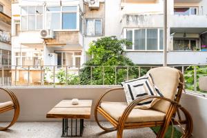 einen Balkon mit einem Stuhl und einem Couchtisch in der Unterkunft Cozy Flat 6 min walking to Taksim square in Istanbul