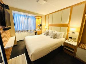 ein Hotelzimmer mit einem großen Bett und einem Fenster in der Unterkunft OQ MIRADOR CLASSIC - AIRPORT in Arequipa