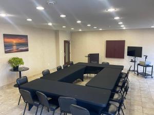 einen Konferenzraum mit schwarzen Tischen und Stühlen sowie einem TV in der Unterkunft MainStay Suites Texas Medical Center-Reliant Park in Houston