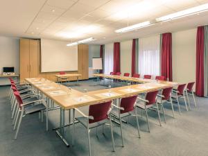 una gran sala de conferencias con una mesa larga y sillas en Mercure Hotel Frankfurt Eschborn Süd, en Eschborn