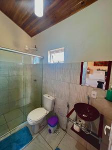 a bathroom with a toilet and a sink and a shower at Chalé Uyuni in Alto Paraíso de Goiás