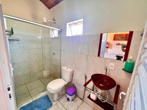 a bathroom with a toilet and a shower and a sink at Chalé Uyuni in Alto Paraíso de Goiás