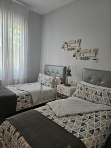 een slaapkamer met 2 bedden en een raam bij Loft17 in Burgos