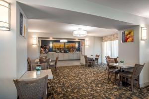 a restaurant with tables and chairs and a kitchen at Best Western Flagship Inn in Moss Point