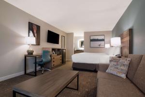 a hotel room with a bed and a couch at Best Western Flagship Inn in Moss Point