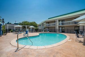 a pool in a courtyard with chairs and a building at Best Western Flagship Inn in Moss Point