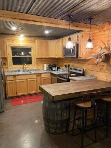uma cozinha com um grande balcão num camarote em Rustic Log Cabin at Swinging Bridge em Heber Springs