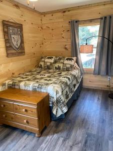 um quarto com uma cama num chalé de madeira em Rustic Log Cabin at Swinging Bridge em Heber Springs