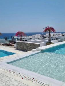 a swimming pool with the ocean in the background at The George Hotel Mykonos in Platis Gialos