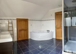 a large bathroom with a tub and a sink at La Gouleote Spacieuse maison type chalet avec jacuzzi, sauna, pétanque in Gérardmer +45 photos