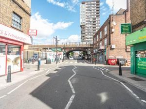 Une rue vide dans une ville avec un pont dans l'établissement Bright Modern 2 Bed Apartment in East London, à Londres