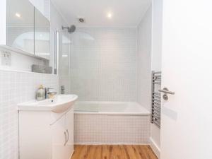 倫敦的住宿－Bright Modern 2 Bed Apartment in East London，白色的浴室设有浴缸和水槽。