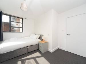 a white bedroom with a bed and a window at Bright Modern 2 Bed Apartment in East London in London