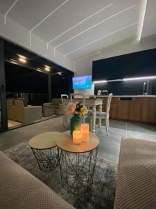 a living room with a table and two chairs and a tv at Apartments Dzaleta in Sveti Stefan